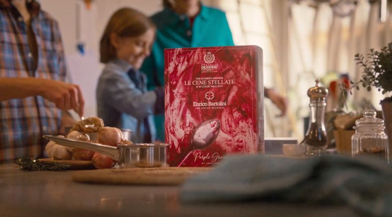 Famiglia in cucina con una confezione regalo Fratelli Desideri sul tavolo