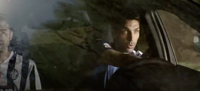 Un uomo alla guida ripreso attraverso il finestrino
