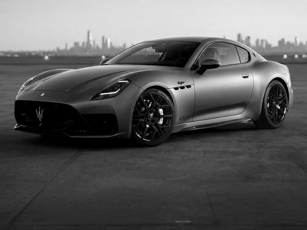 Maserati GranTurismo in bianco e nero su un tetto, con lo skyline sullo sfondo