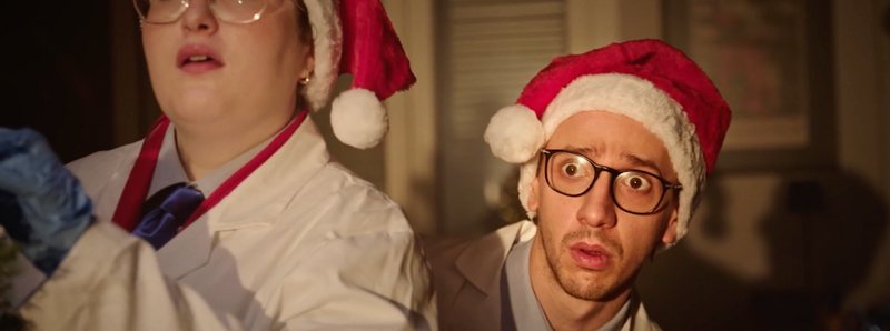 Due attori con cappello da Babbo Natale nel video di Natale di TÜV SÜD